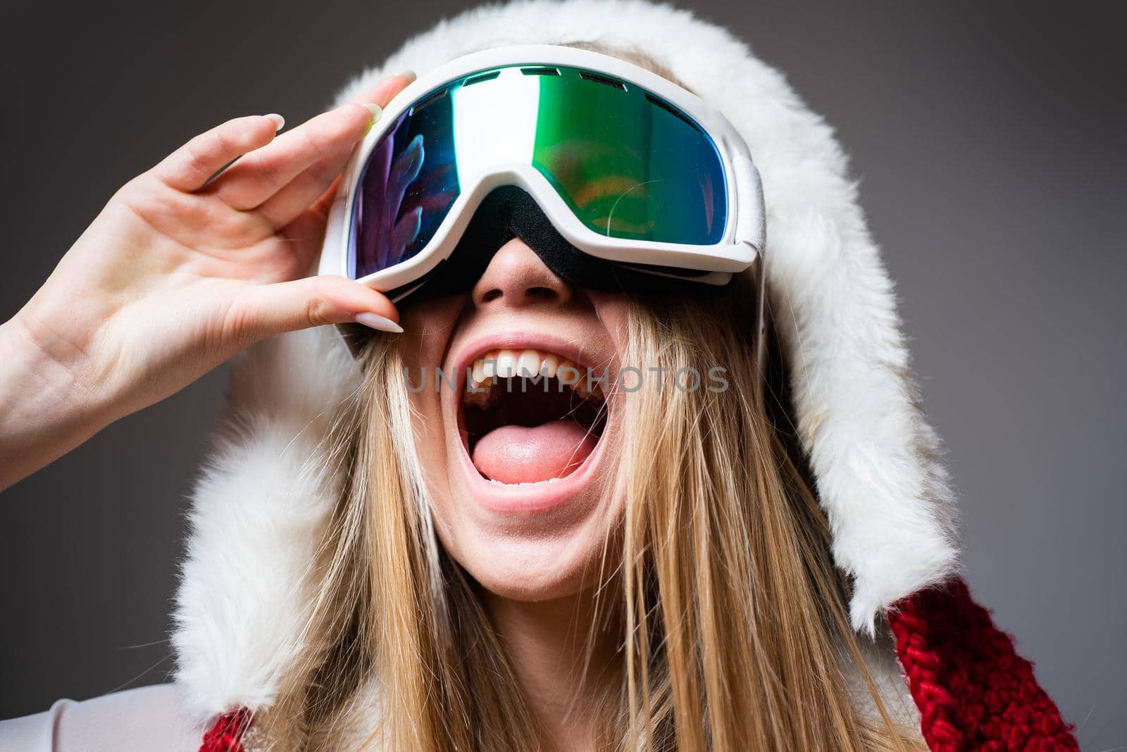 Ski mask. Sport. Extreme sport. Winter leisure. Laughing happy girl with ski mask on grey background. Snowboard glasses. Winter activities. Winter sport and activity. Portrait of a happy young girl isolated