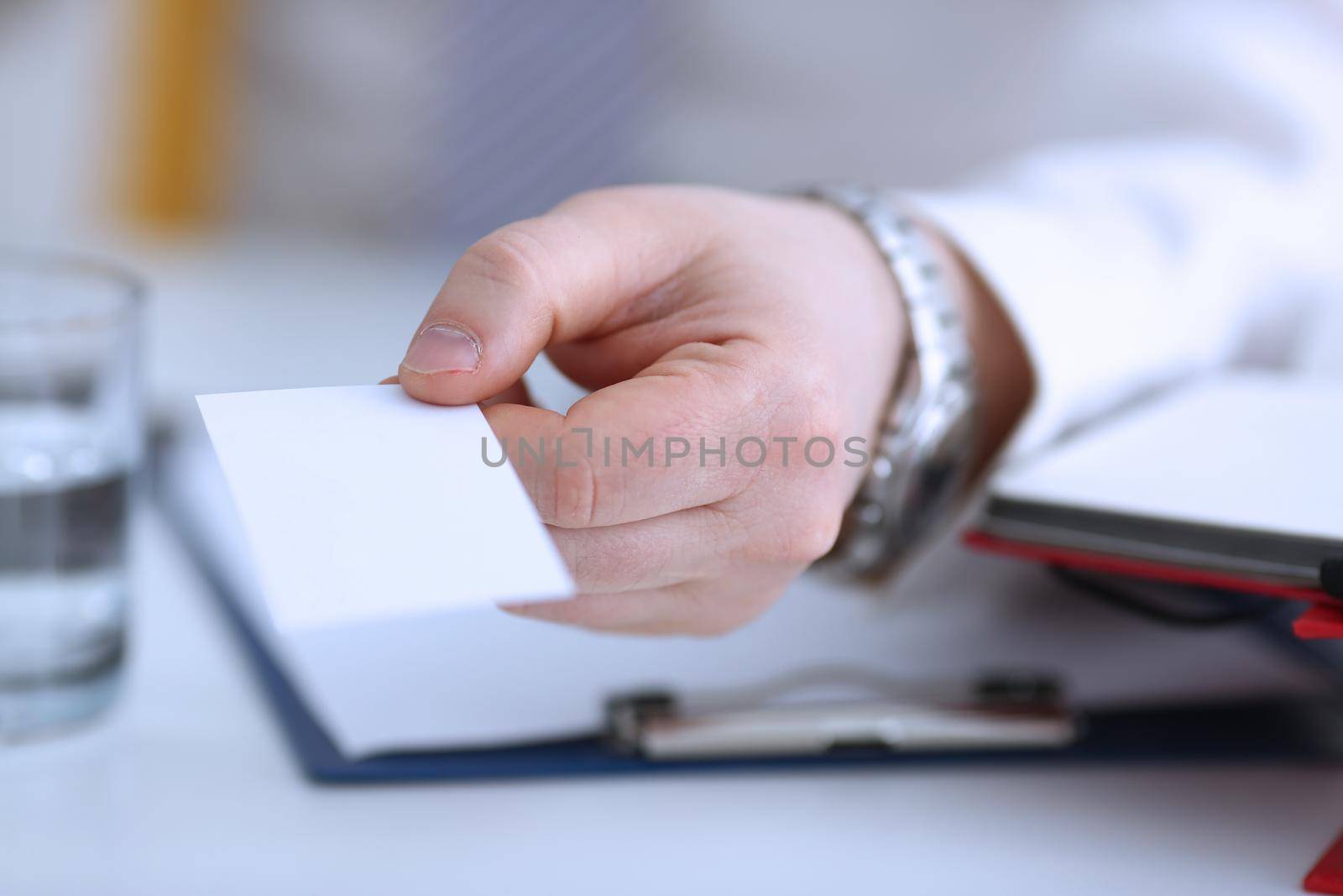Male arm in suit give blank calling card to visitor closeup. White collar colleagues company name exchange job interview sale clerk id executive or ceo finance support formal identity concept