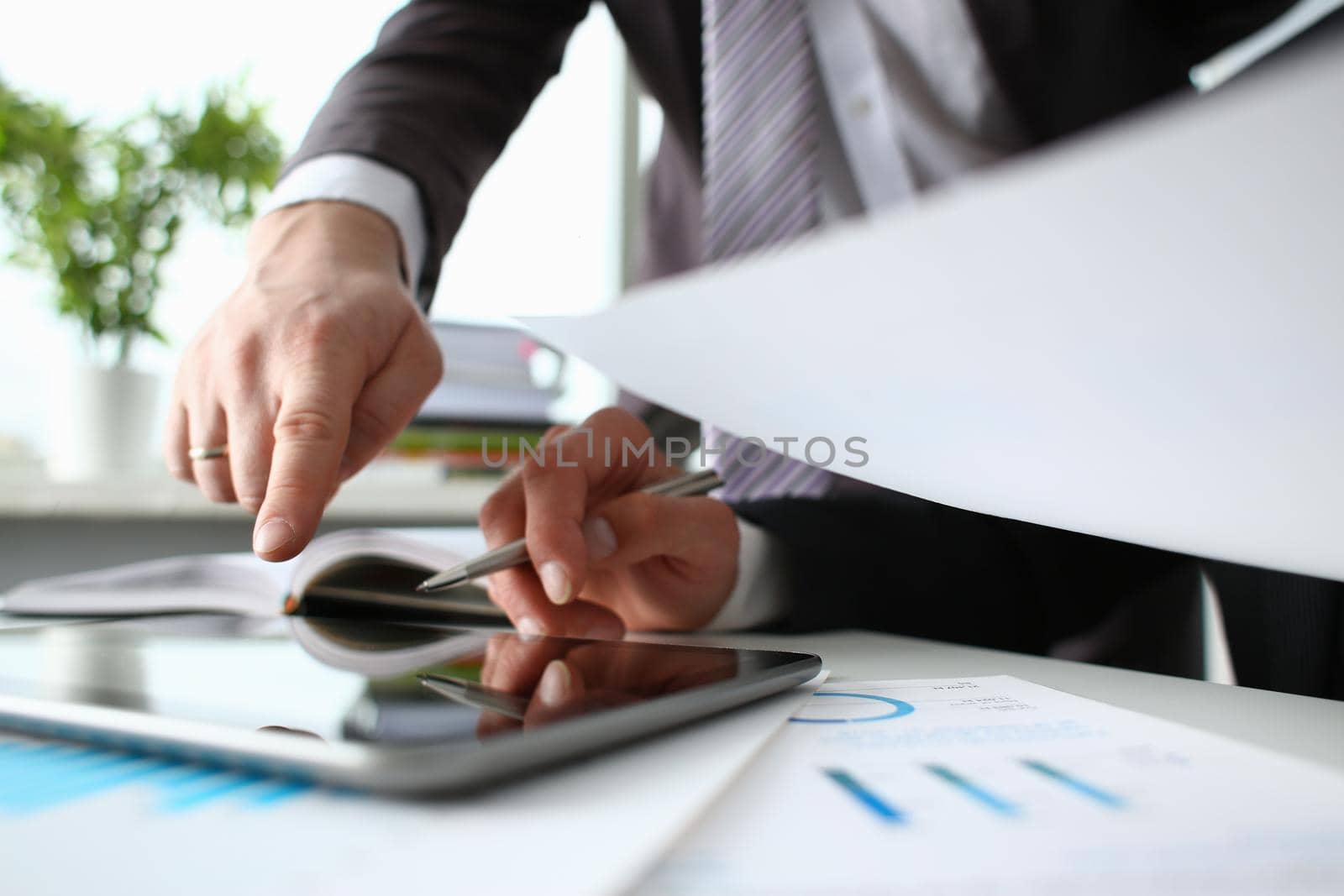 Two businessman are looking and studying statistics on tablet display closeup. Male hand opponent holds pen and points out problem collaboration business coach cooperation partnership palm concept