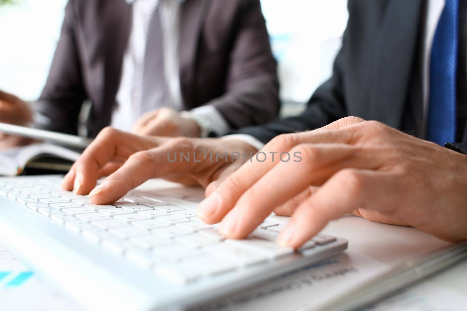 Male arms in suit typing on white by kuprevich