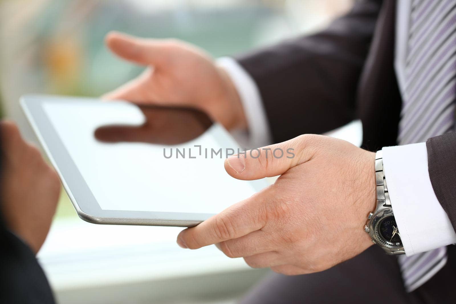 Two businessman are looking and studying statistics on tablet display closeup. Male hand opponent holds pen and points out problem collaboration business coach cooperation partnership palm concept