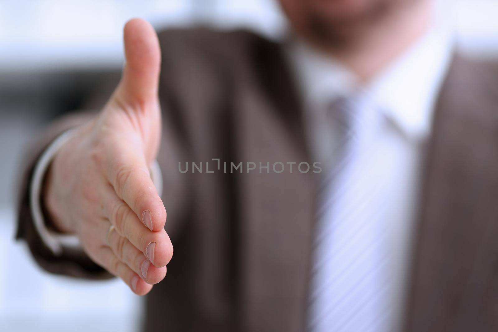 Man in suit and tie give hand as hello in office closeup. Friend welcome mediation offer positive introduction thanks gesture summit participate approval motivation male arm strike bargain