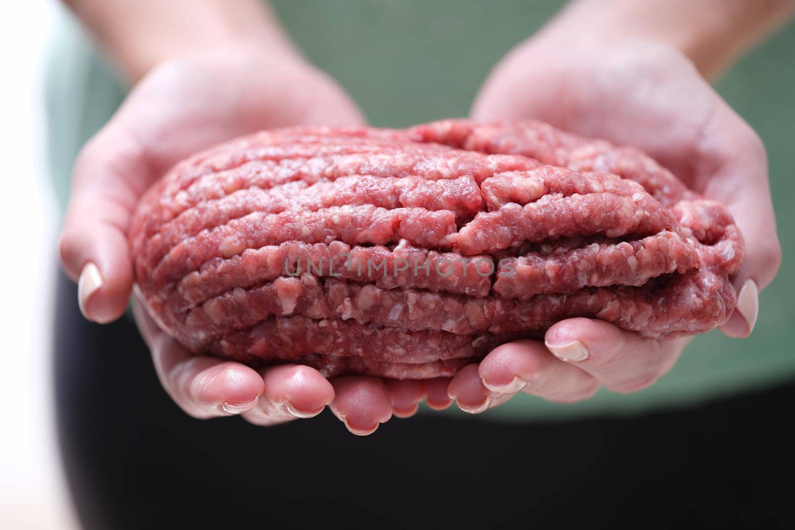 Female hands holding minced beef meat closeup. Meat recipes concept