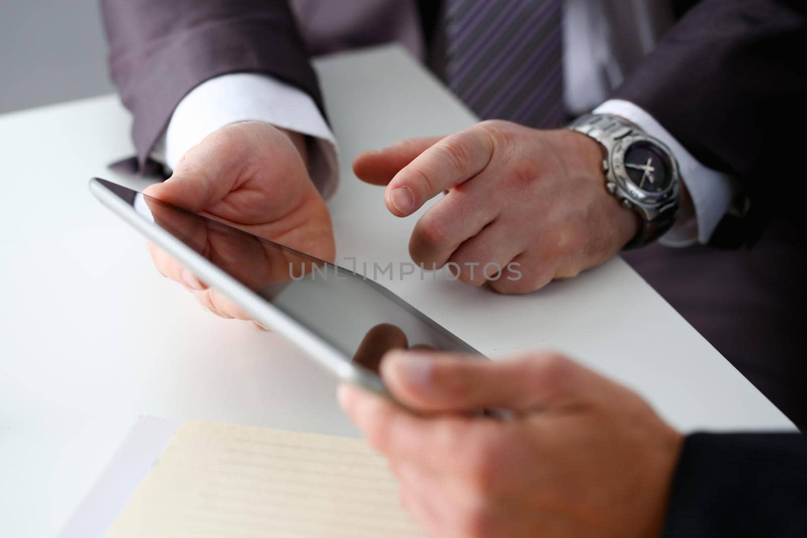 Hand of businessman in suit filling and signing with silver pen partnership agreement form clipped to pad closeup. Management training course some important document, team leader ambition concept