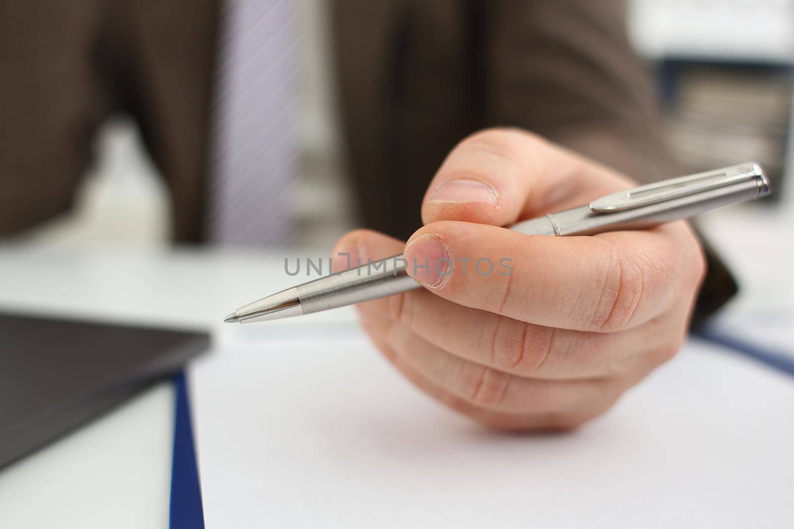 Male arm in suit and tie hold silver pen by kuprevich