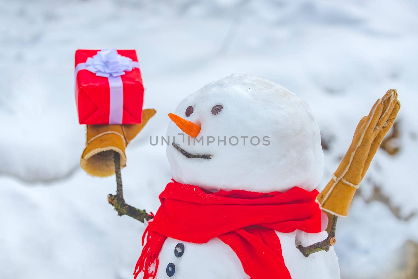 Snowman with shopping bag and gift on the white snow background. Greeting snowman. Merry Christmas and happy new year greeting card with copy-space