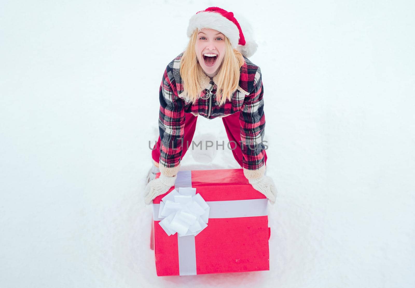 Winter woman with gift. Christmas Woman holding a huge gift box. Woman present red gift box with ribbon bow isolated over white background. Big gift box