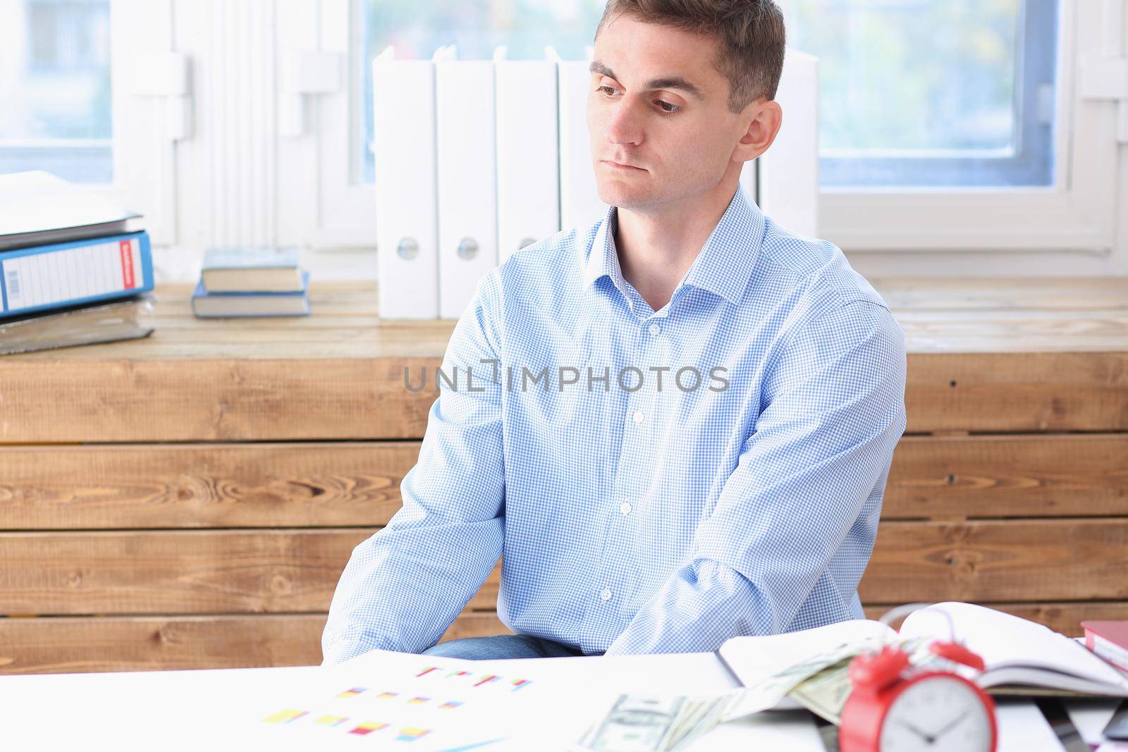 Businessman in blue shirt is bored and sad at office portrait