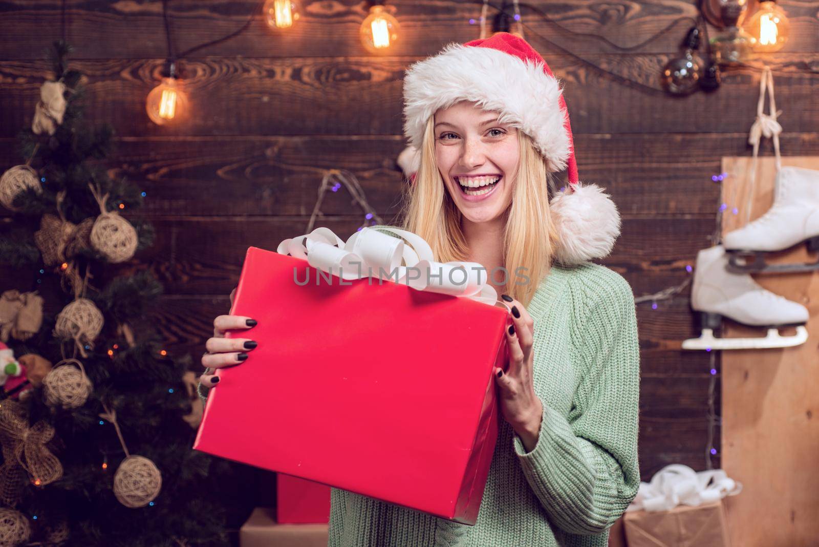Young woman with christmas present boxes in front of christmas tree. Winter eve night emotion reactions. Funny happy face