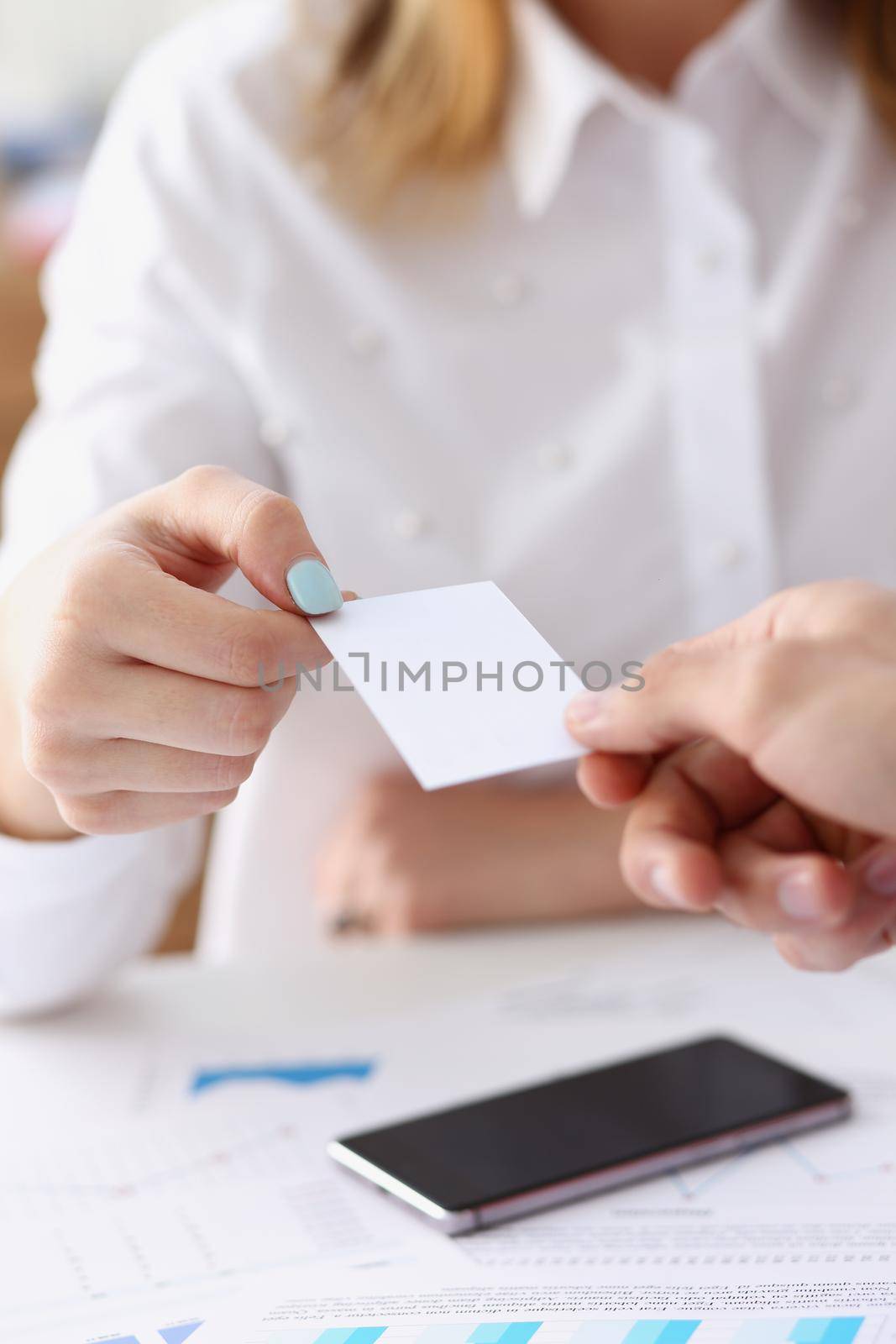 Female hand in suit give blank calling card to female by kuprevich