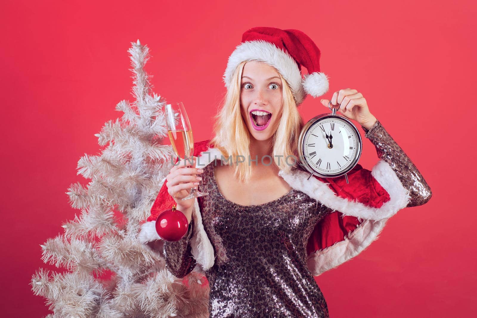 Fun young woman with santa hat. Funny girl in santa clause costume. Portrait of a young smiling woman. Funny Laughing Surprised Woman Portrait