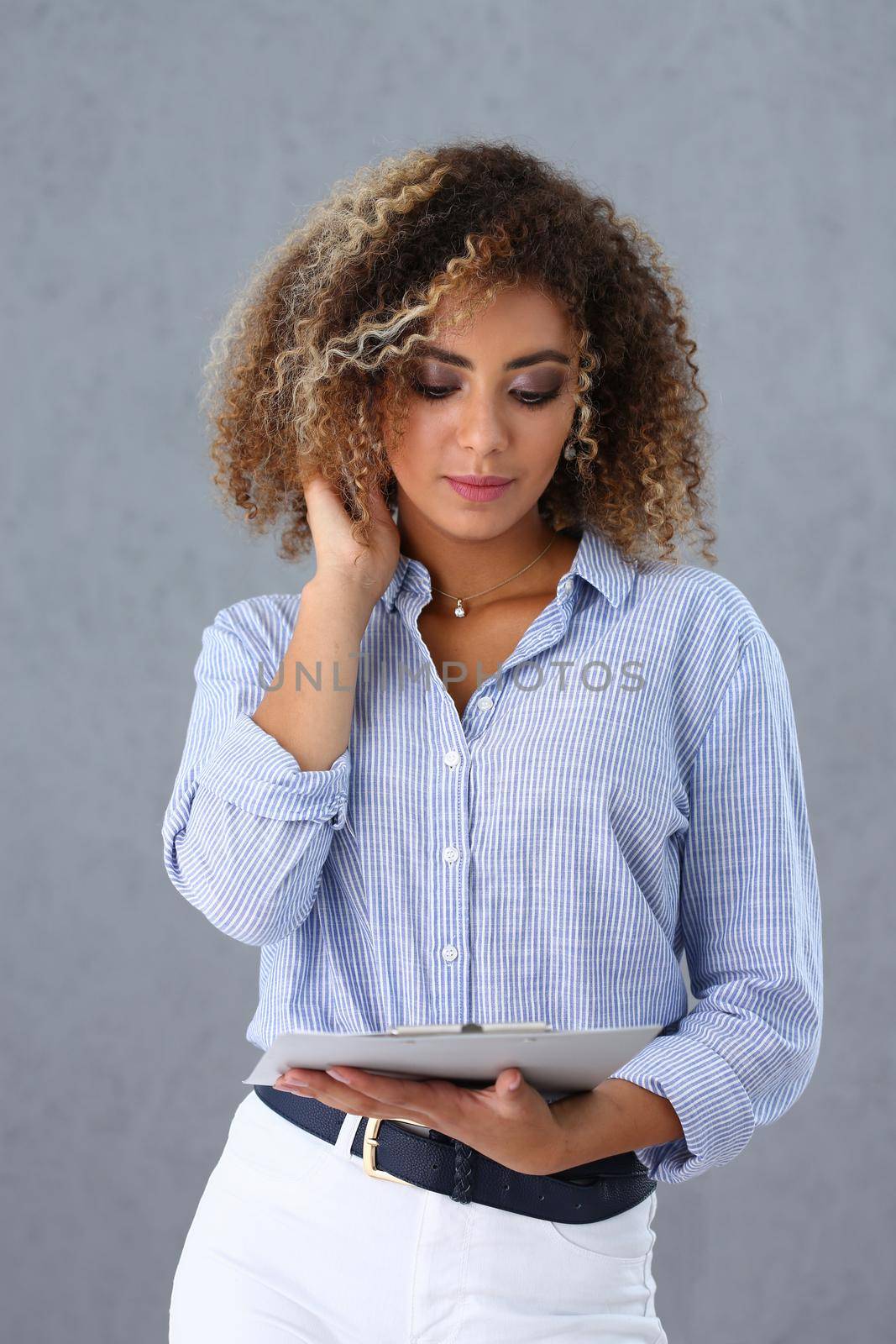 Beautiful black woman portrait. Holds a clipboard with financial statistics fashion style curly hair with white locks eye view of the camera