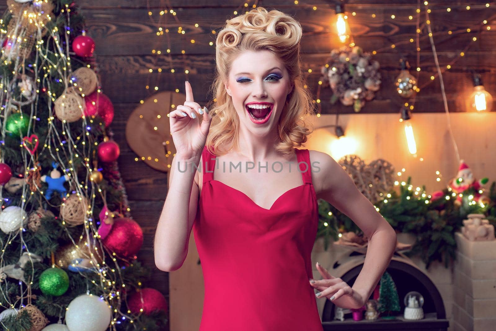 Beautiful happy Christmas woman at celebration party. Beautiful woman on new year and Christmas. Hairstyle and make-up. Crazy comical face. Give a wink