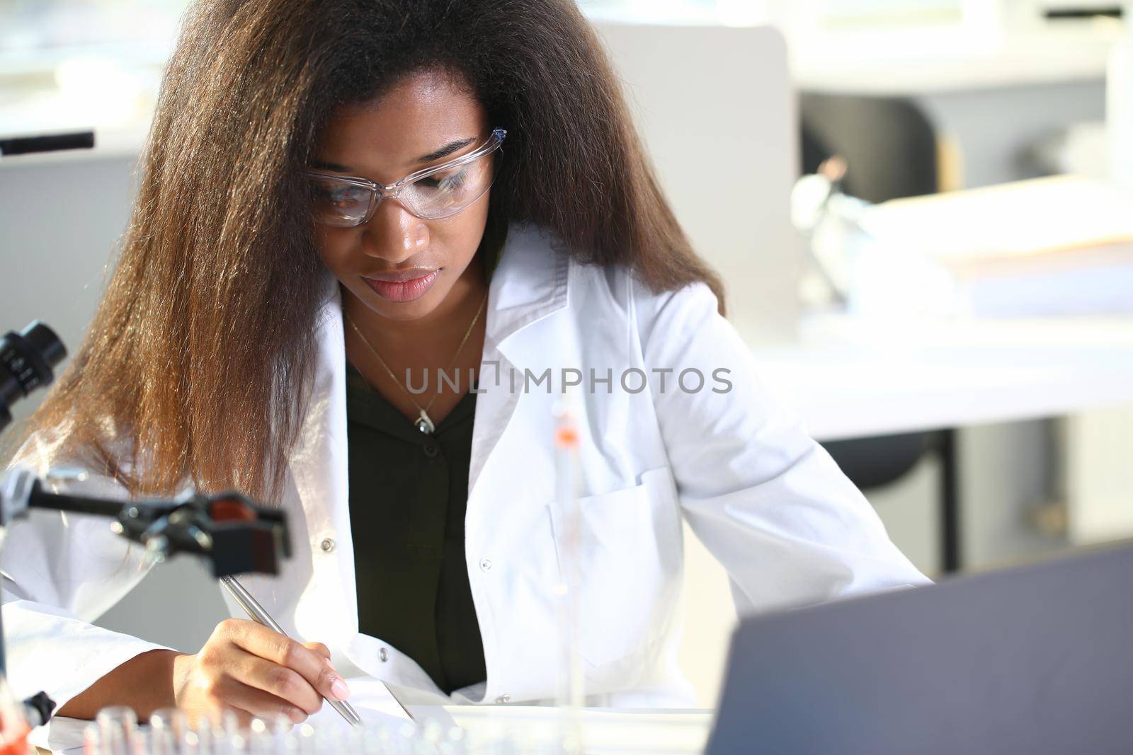 Black female chemist student conducting research by kuprevich