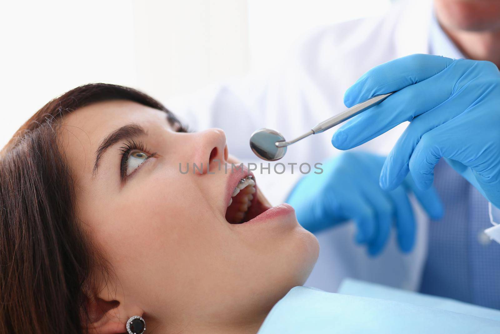 A woman at the reception of a male dentist examining by kuprevich