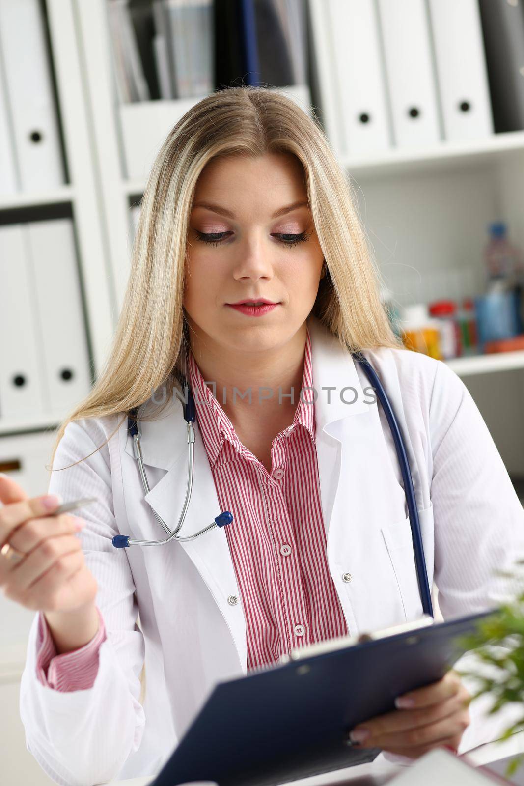 Beautiful smiling female doctor hold clipboard by kuprevich