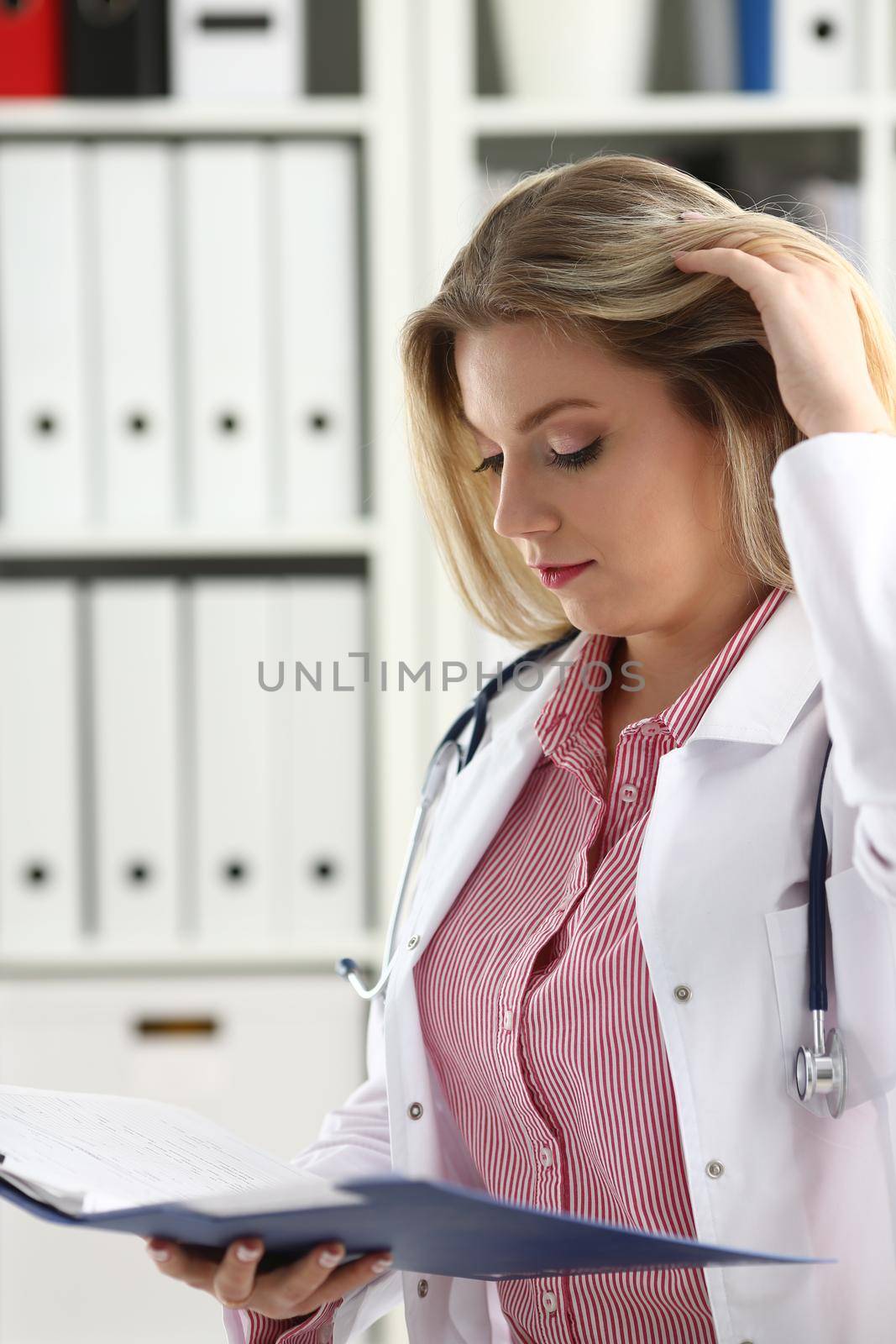 Beautiful smiling female doctor hold clipboard by kuprevich