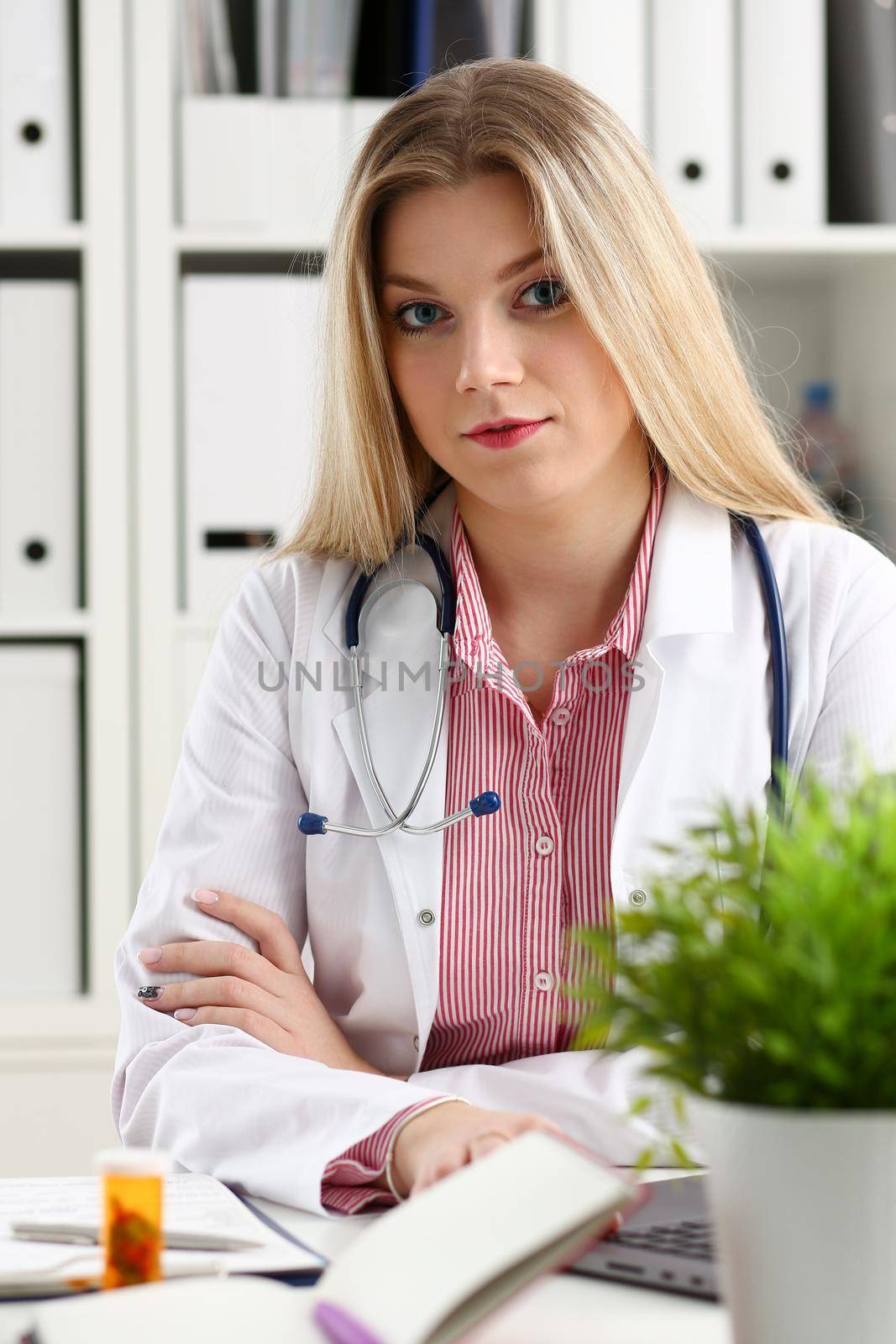 Beautiful smiling female doctor sit at workplace. Physical and disease prevention, patient aid, exam visit, 911, ward round, prescribe remedy, healthy lifestyle, consultant profession concept