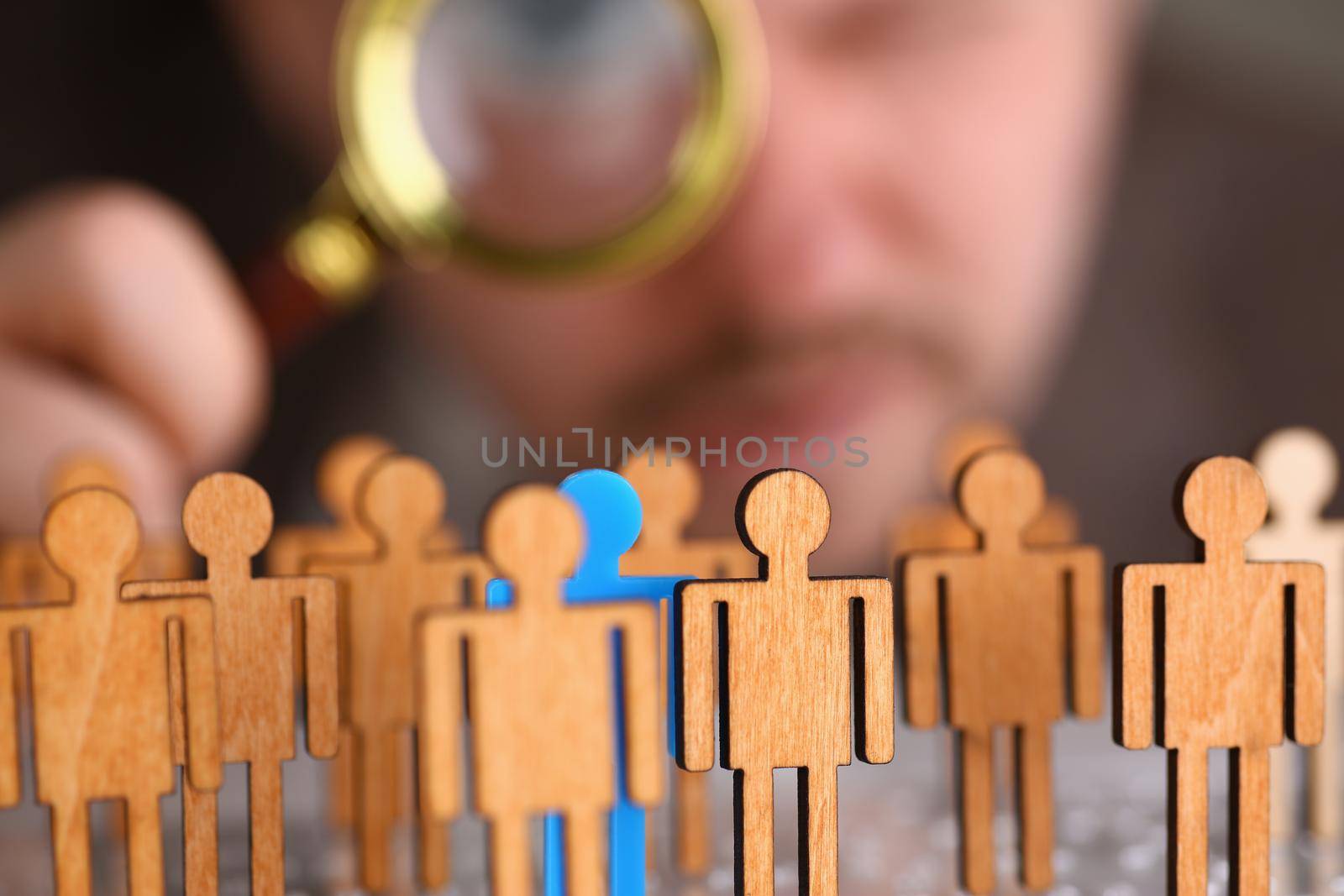 Man in suit look thru loupe on statuettes closeup by kuprevich