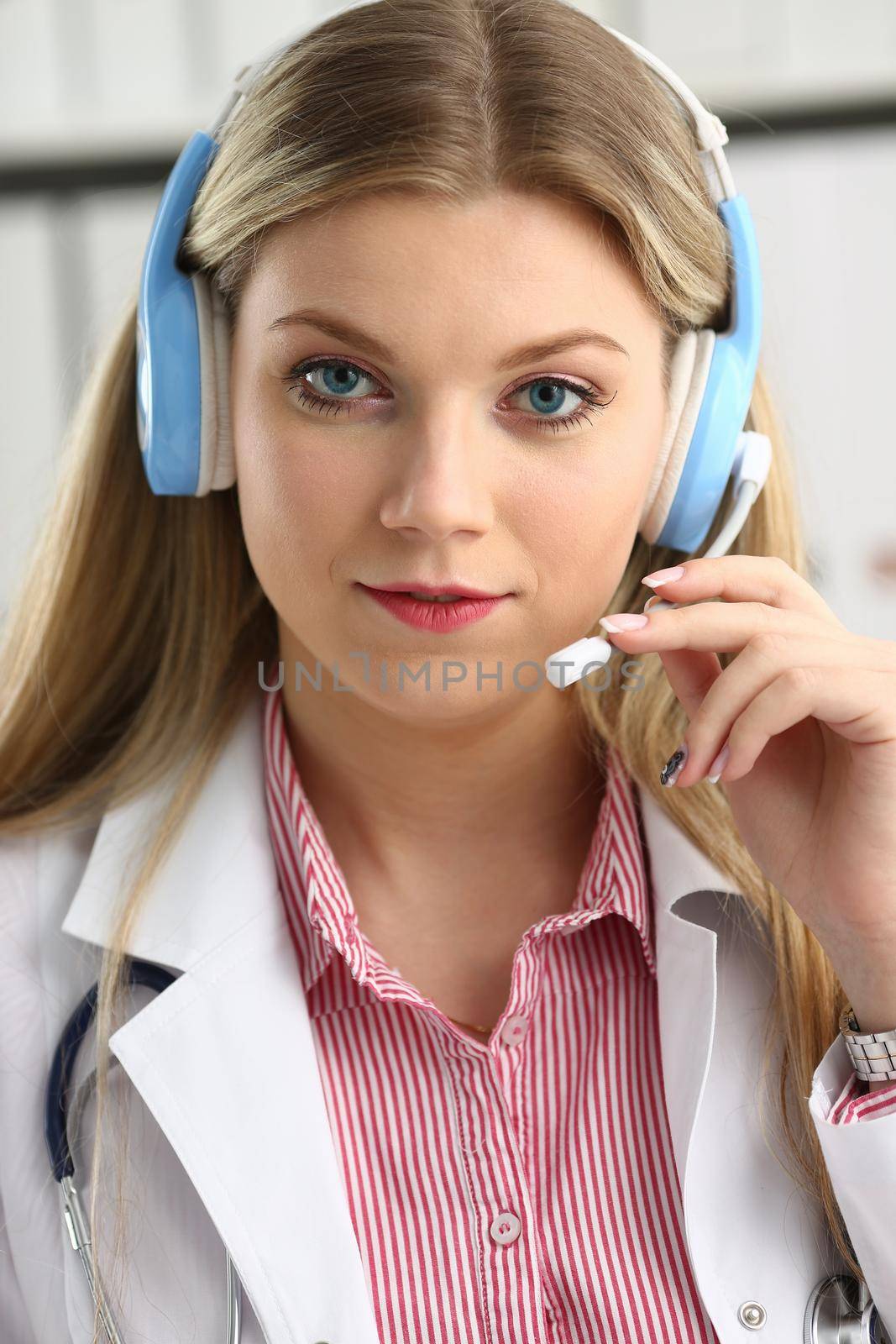 Portrait of happy smiling young doctor in headset by kuprevich