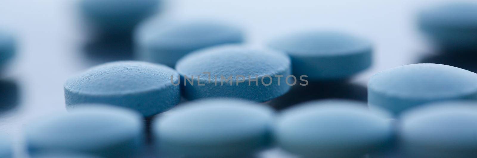 Tablets scattered blue color on the table of pharmaceutical laboratory pill for the prescription and treatment various diseases chemistry