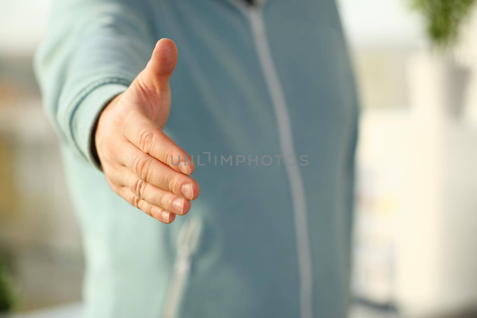 Man in sport suit and tie give hand as hello in office closeup. Friend welcome mediation offer, positive introduction thanks gesture summit participate approval motivation male arm strike bargain