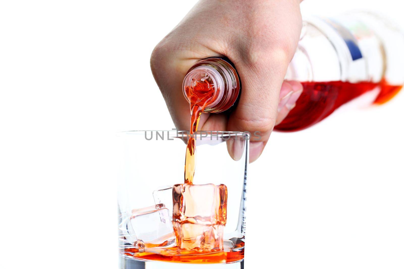 Male hand pours from bottle drink for a cocktail in glass beaker background