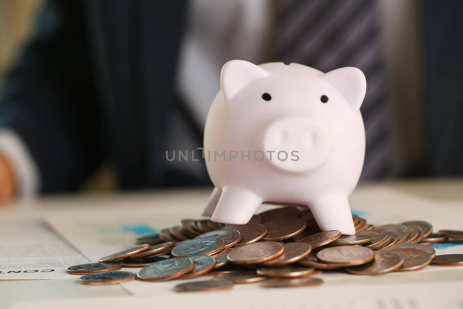 Hand businessman putting pin money into pig by kuprevich