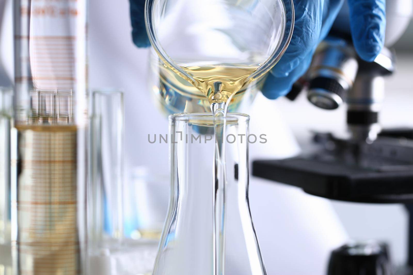 Male hand hold yellow liquid in test tube. Conveyor line production household cleaning products detergents help cleaning destruction stains pests urine poison antidote vaccine concept.