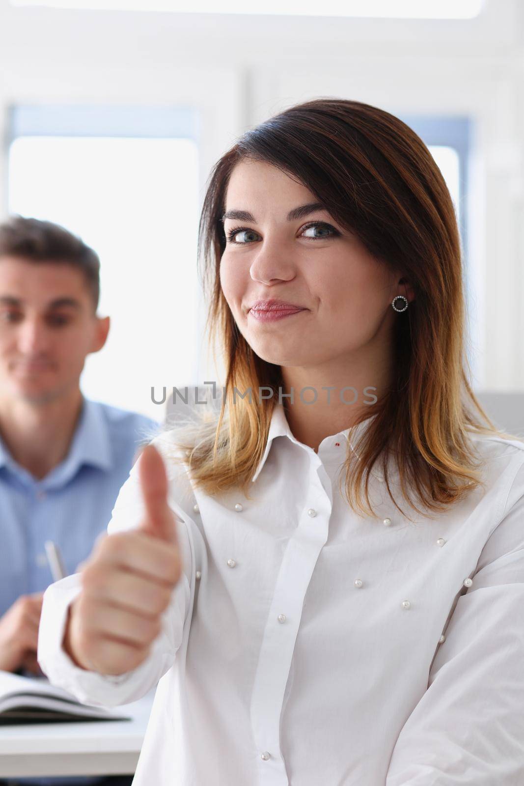 Female hand showing ok or approval sign with thumb up in creative people office during conference. High level and quality service job offer excellent education advisor serious business concept okay