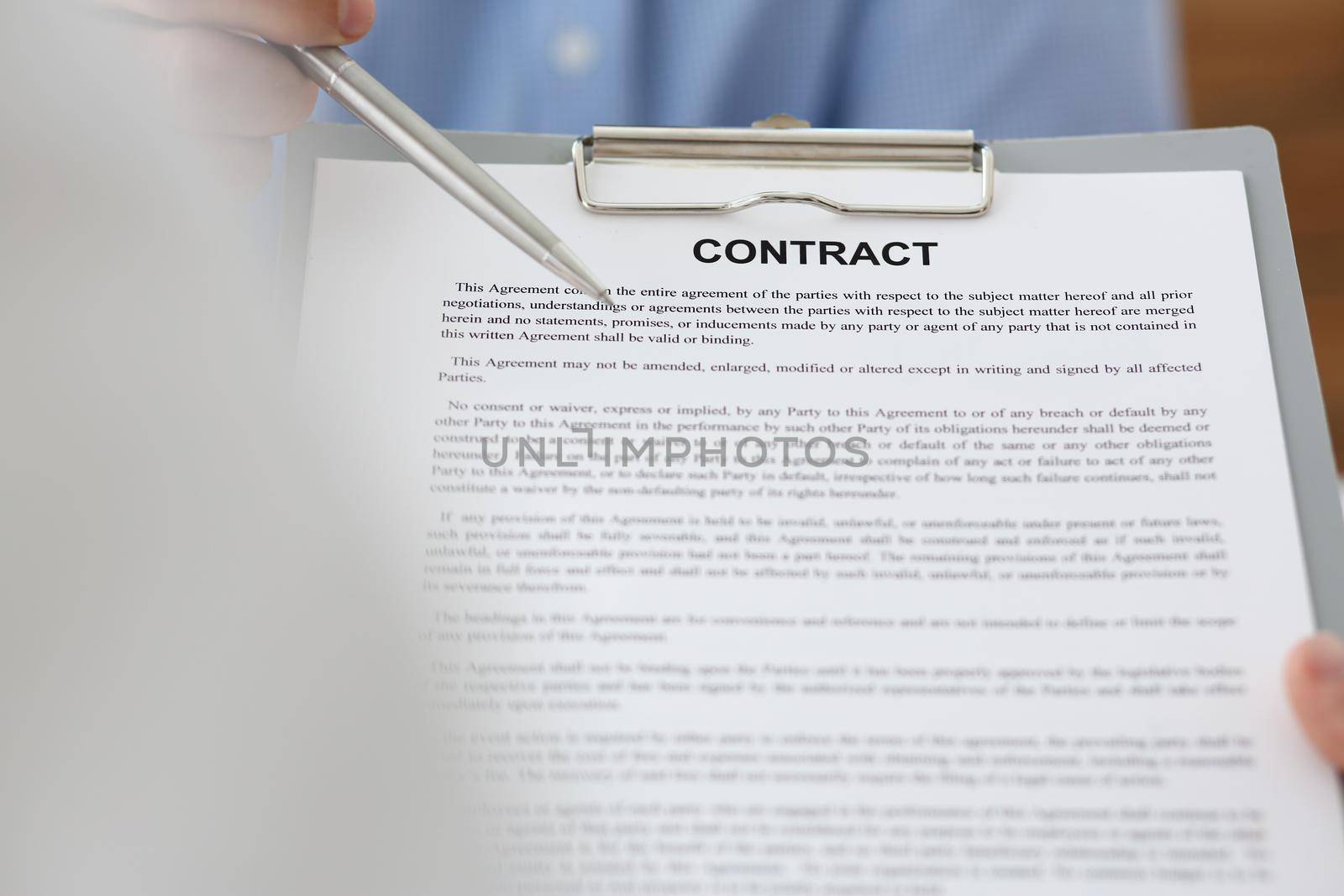 Female arm in suit offer contract form on clipboard pad and silver pen to sign closeup. Strike a bargain for profit white collar motivation union decision corporate sale insurance agent concept