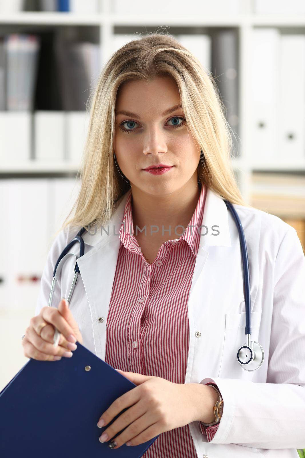 Beautiful smiling female doctor hold clipboard by kuprevich