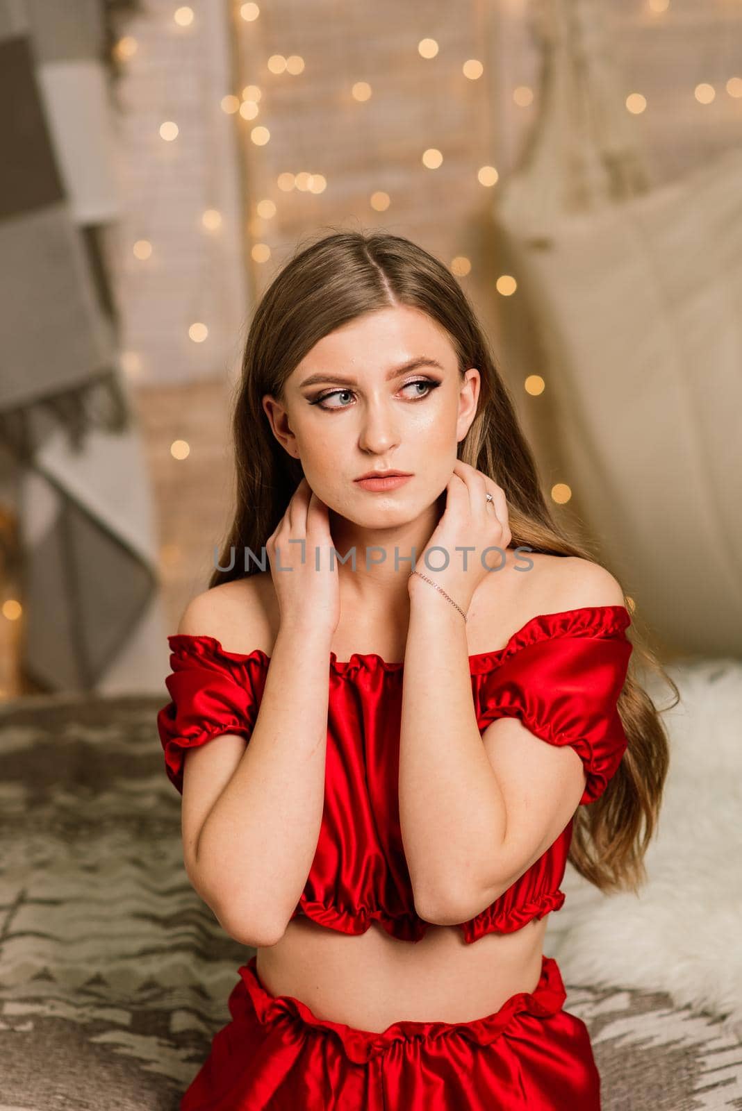 Happy young lady with long hair near fireplace and the Christmas tree, gifts. New year concept.