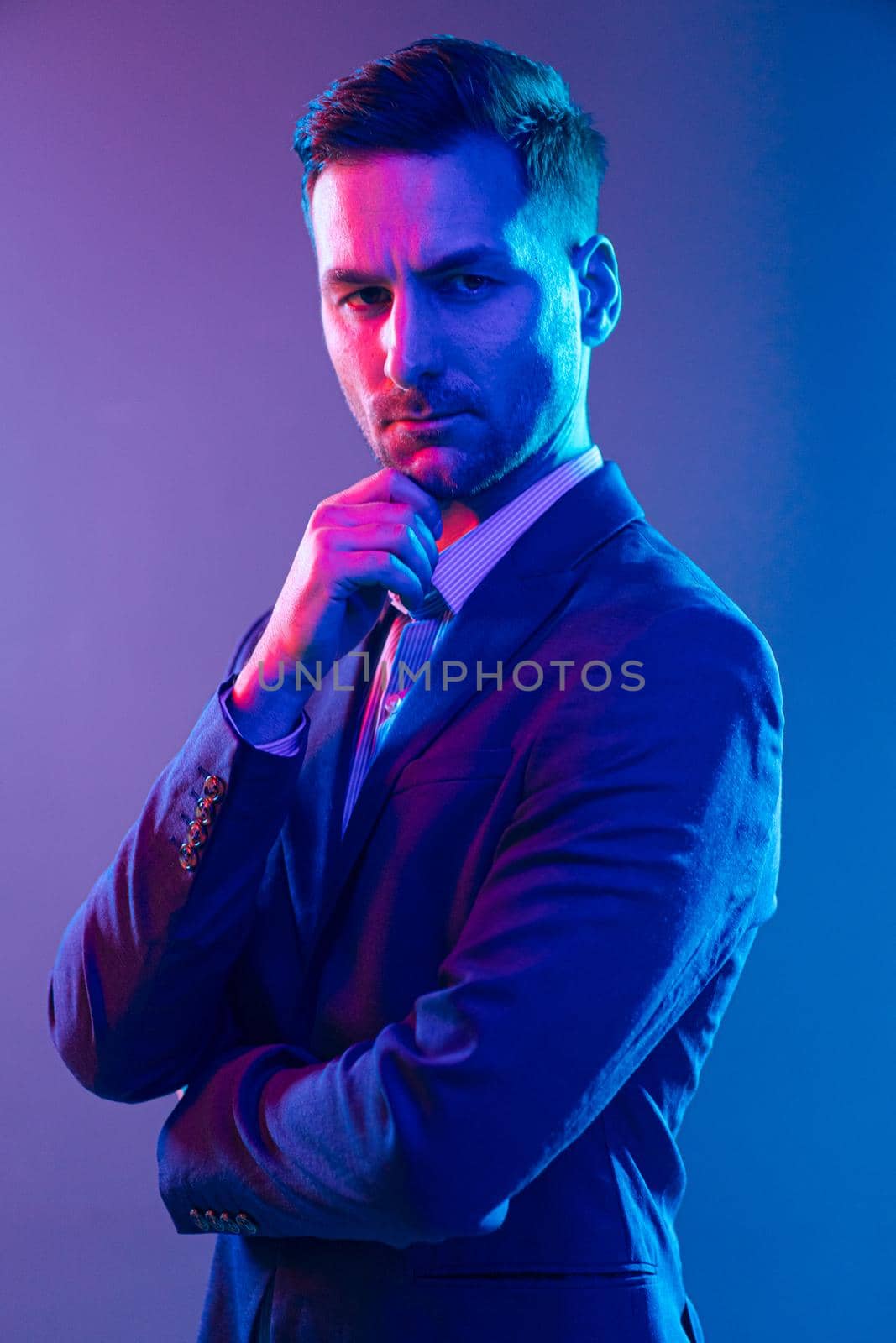 Expensive Lawyer Before a Court Hearing, The Chief Decision Maker for the Business. The Portrait of a White Man Posing in Studio With Multicolored Neon Light on a Gray Background. High quality photo