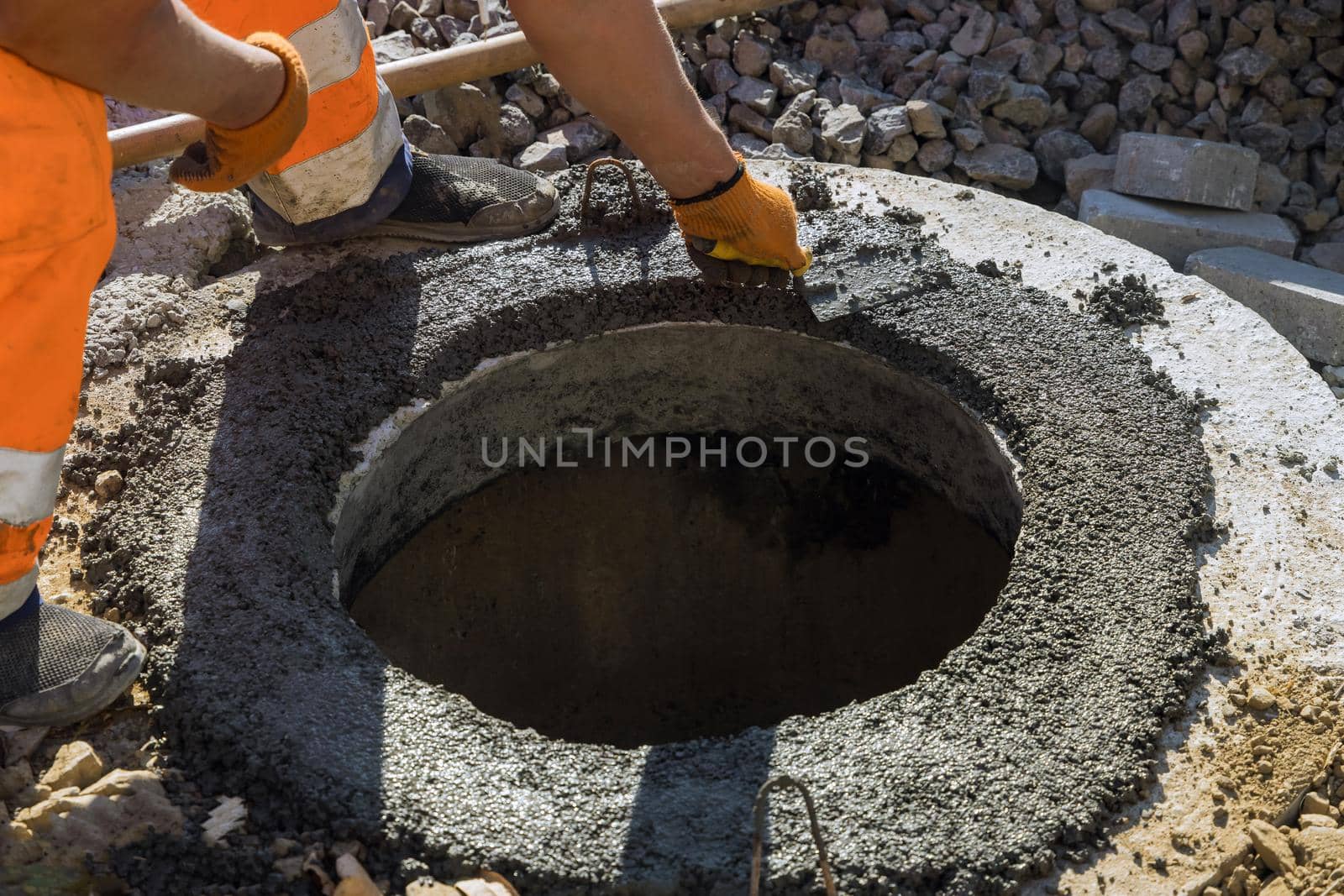 A worker the new road construction work on preparation for installation of sewer manholes hatches