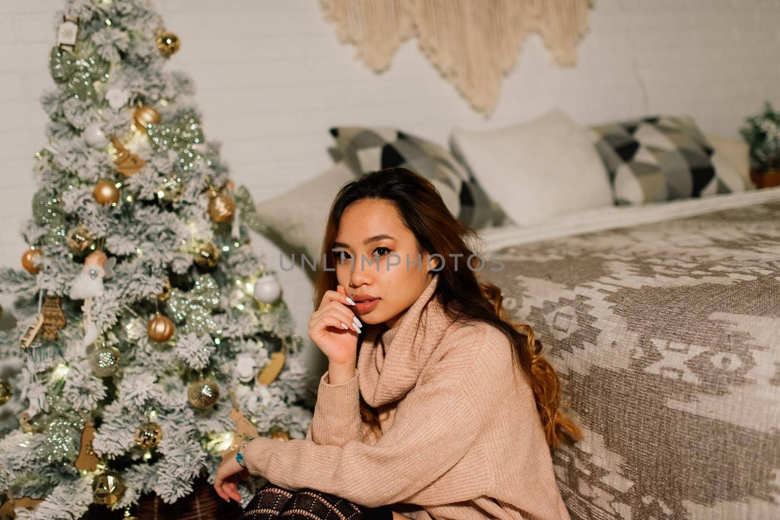 Beautiful young asian woman celebrating christmas at home, having fun opening presents