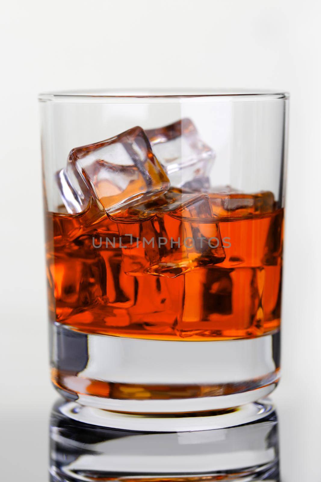 Whiskey with ice in glass beaker on by kuprevich