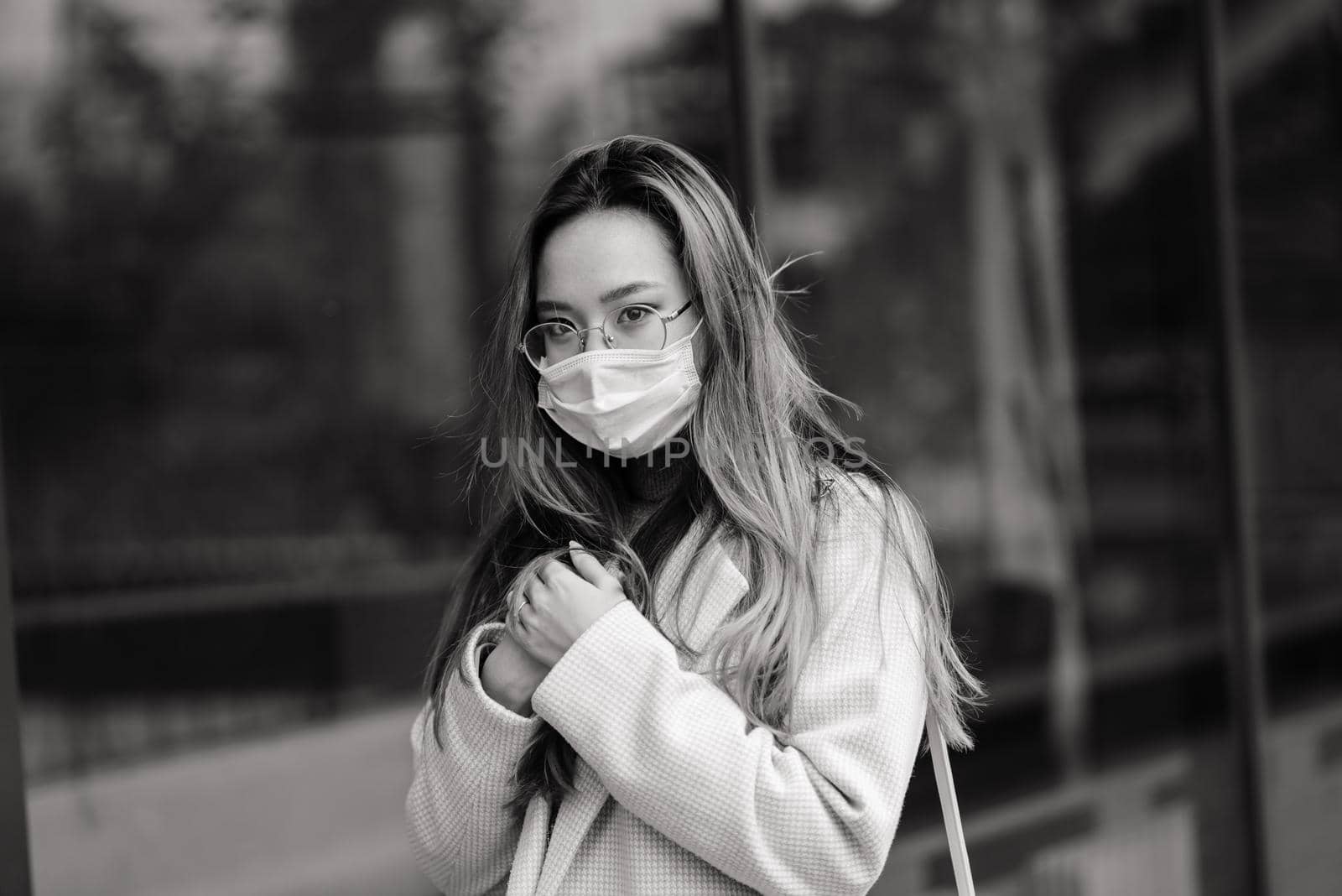 Young asian woman wearing face mask is standing at a domestic street. New normal covid-19 epidemic by Zelenin