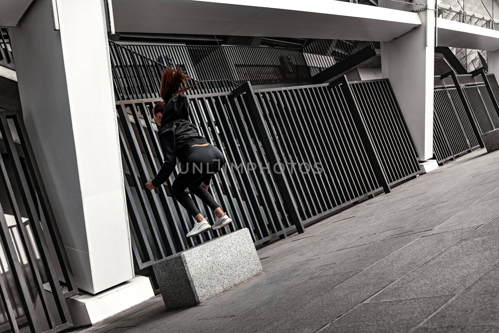 Young woman doing leg exercises with stoned step platform by friendsstock