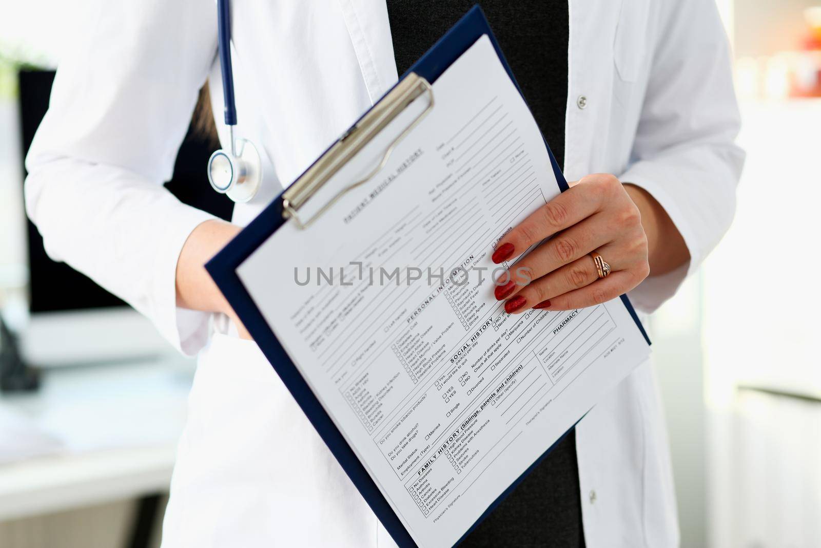 Female doctor hand holding and filling patient history list at clipboard pad during physical. Exam er disease prevention ward round visit check 911 prescribe remedy healthy lifestyle concept.