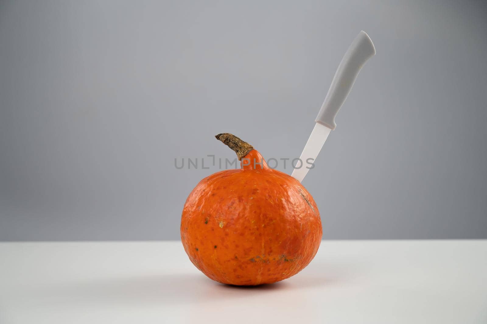 Knife in a pumpkin on a white background. Halloween symbol. by mrwed54
