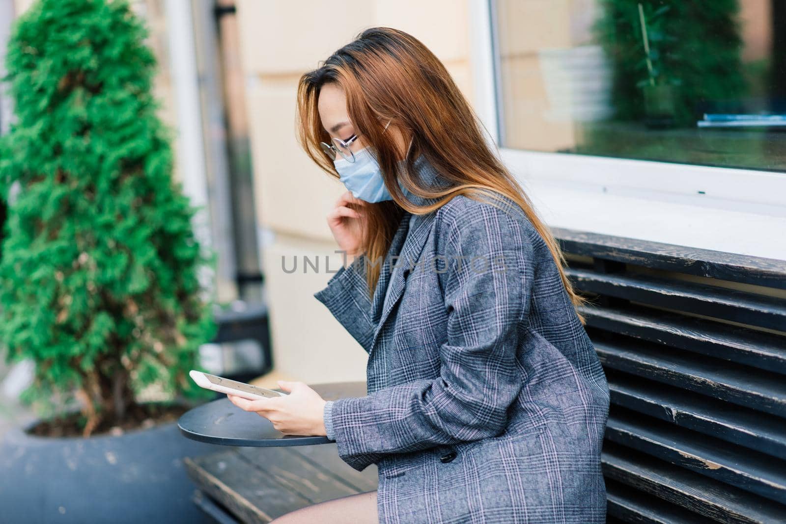 Young fsian woman wearing face mask is standing at a domestic street. Concept new normal of commuters after covid-19 epidemic