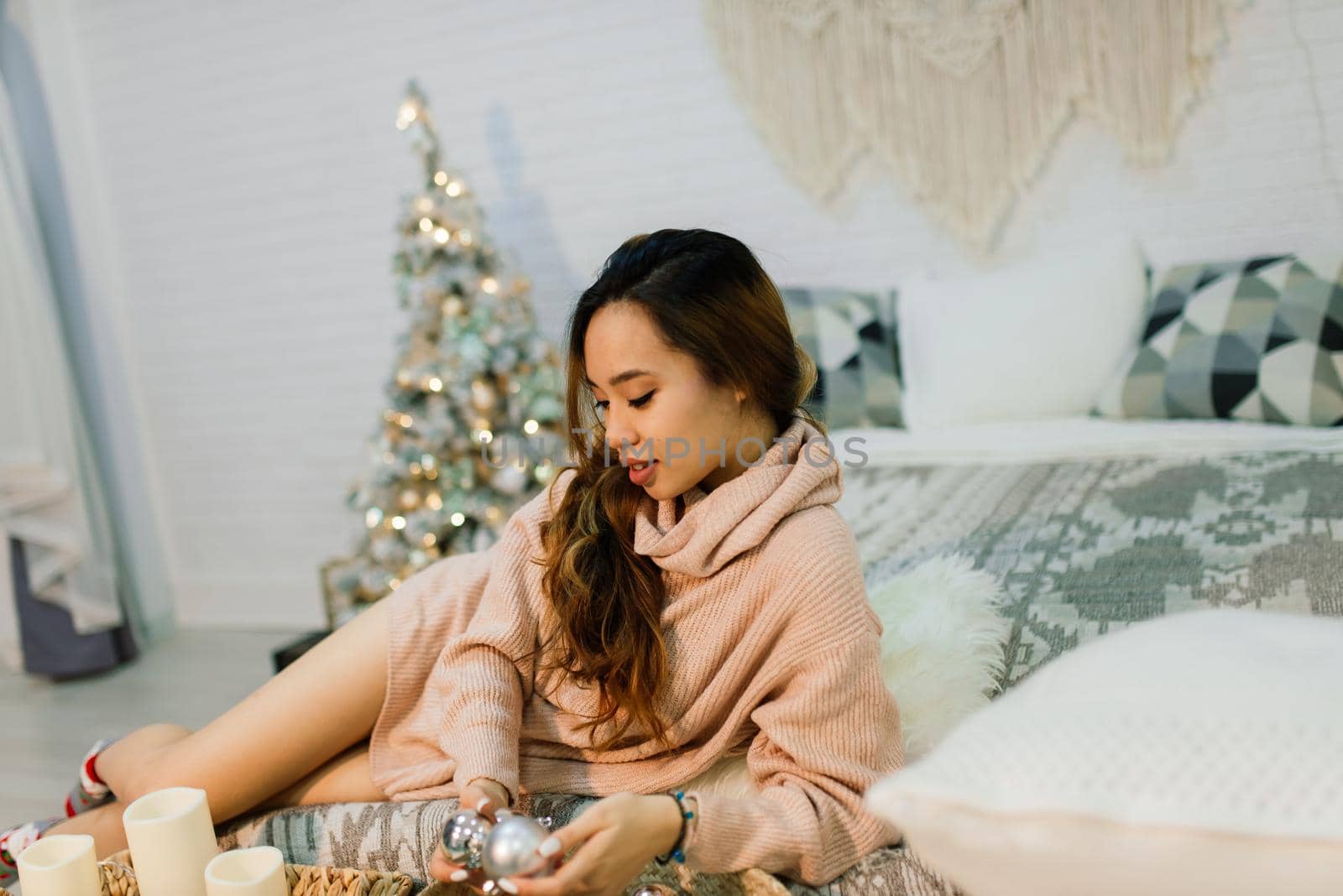 Beautiful young asian woman celebrating christmas at home, having fun opening presents