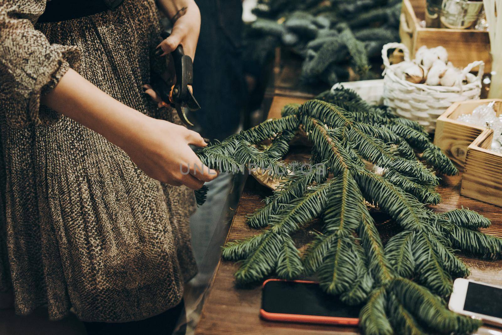 Master class on creating a Christmas wreath with your own hands. Decoration for the house for Christmas. Woman making christmas wreath. Creating a Christmas wreath of spruce branches.