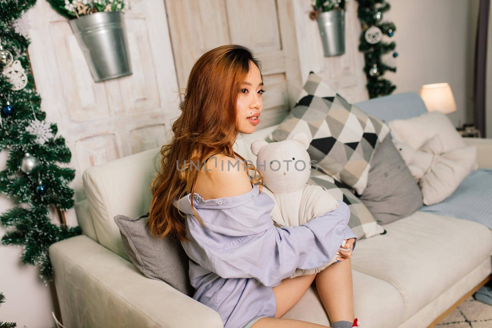 Beautiful young asian woman celebrating christmas at home, having fun while opening presents by Zelenin