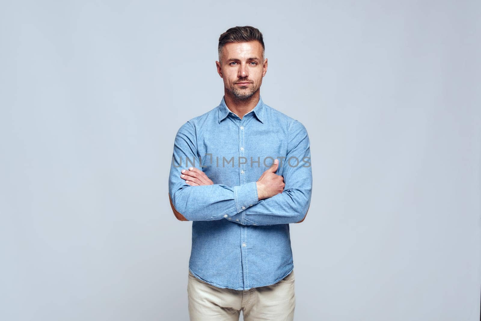 Portrait of young handsome bearded man in casual wear standing with crossed arms and looking at camera by friendsstock