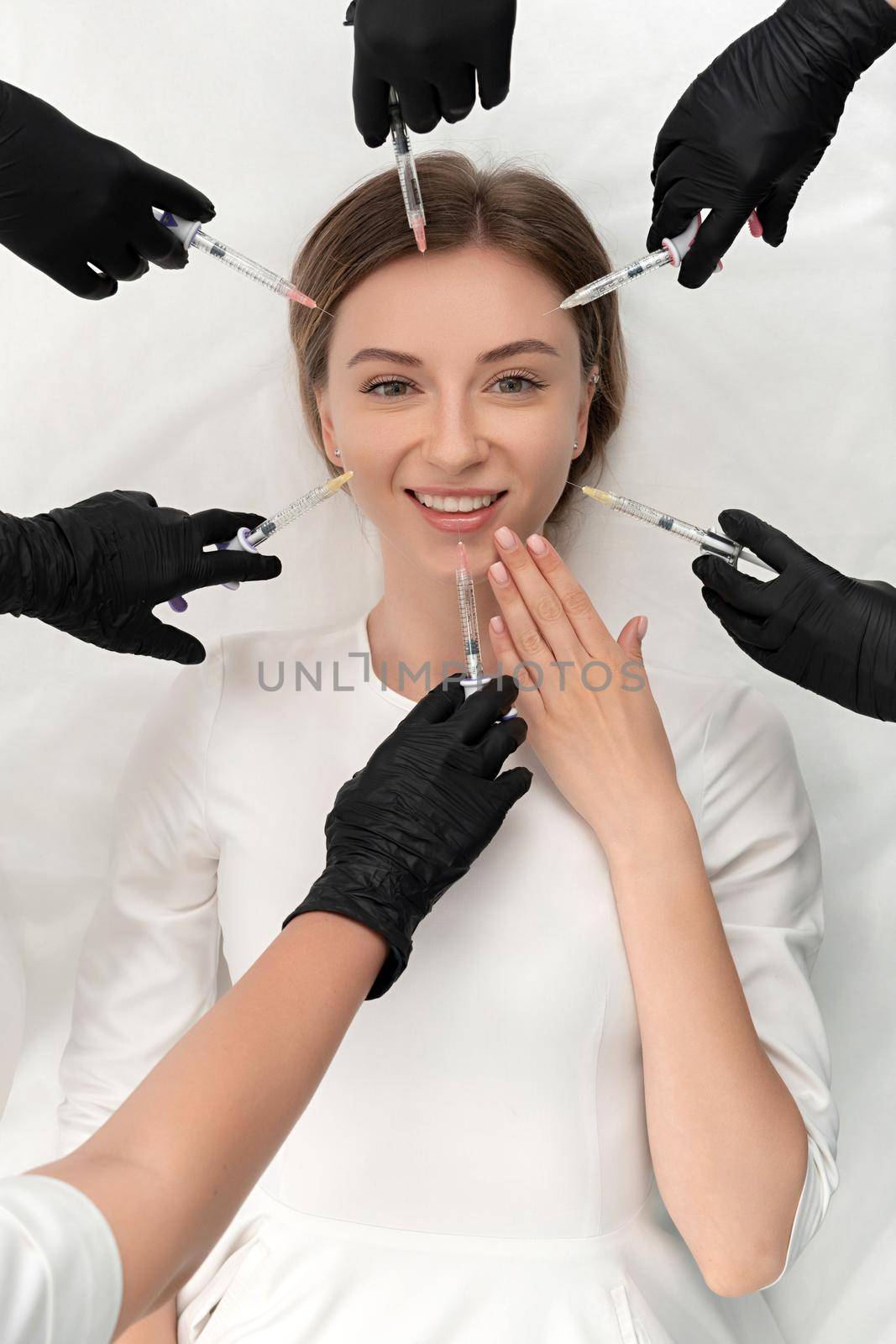 Conceptual beauty and cosmetology image of hands of several doctors holding syringes. Beauty and Cosmetology concept. Cosmetic procedures mesotherapy by Mariakray