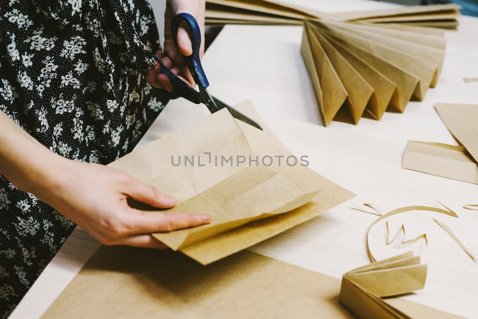 Creating hand made christmas ornaments. Snowflake or three-dimensional star made of kraft paper. by Rodnova