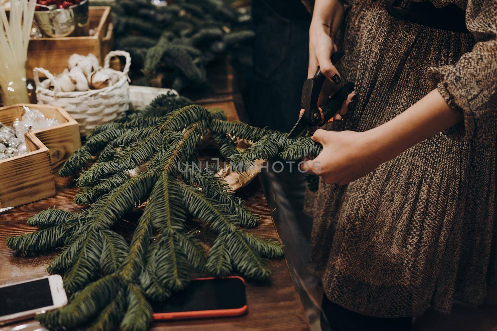 Woman making christmas wreath. A master class on creating a Christmas wreath from a natural spruce with your own hands. A Christmas wreath made with your own hands.