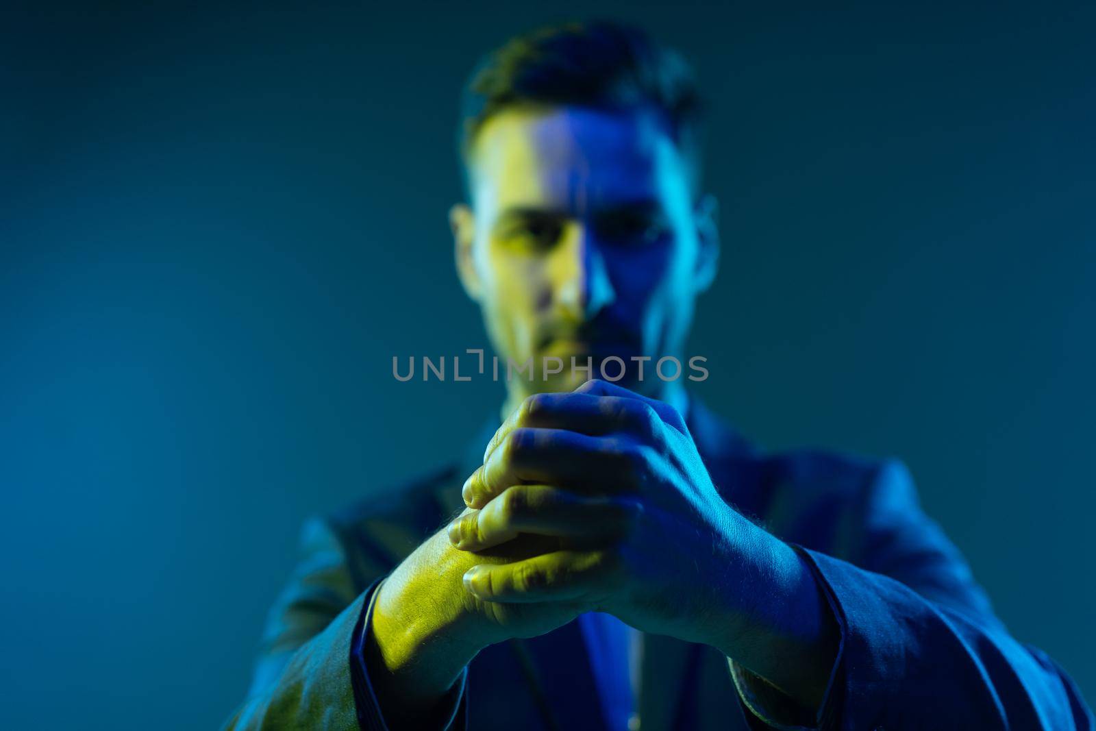 Folded Hands. Leader is Ready to Act Decisively in All Situations. Selective Focus of Folded Hands in Neon Light. Gray background. High quality photo